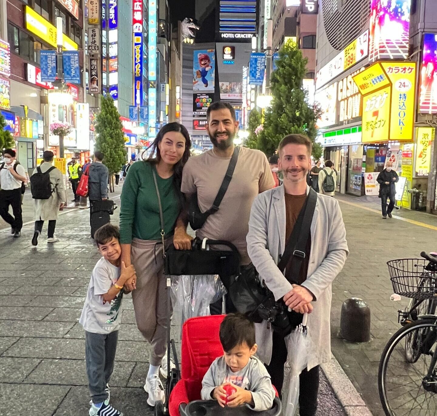 Carlos con una familia viajera en una calle iluminada de Tokio por la noche
