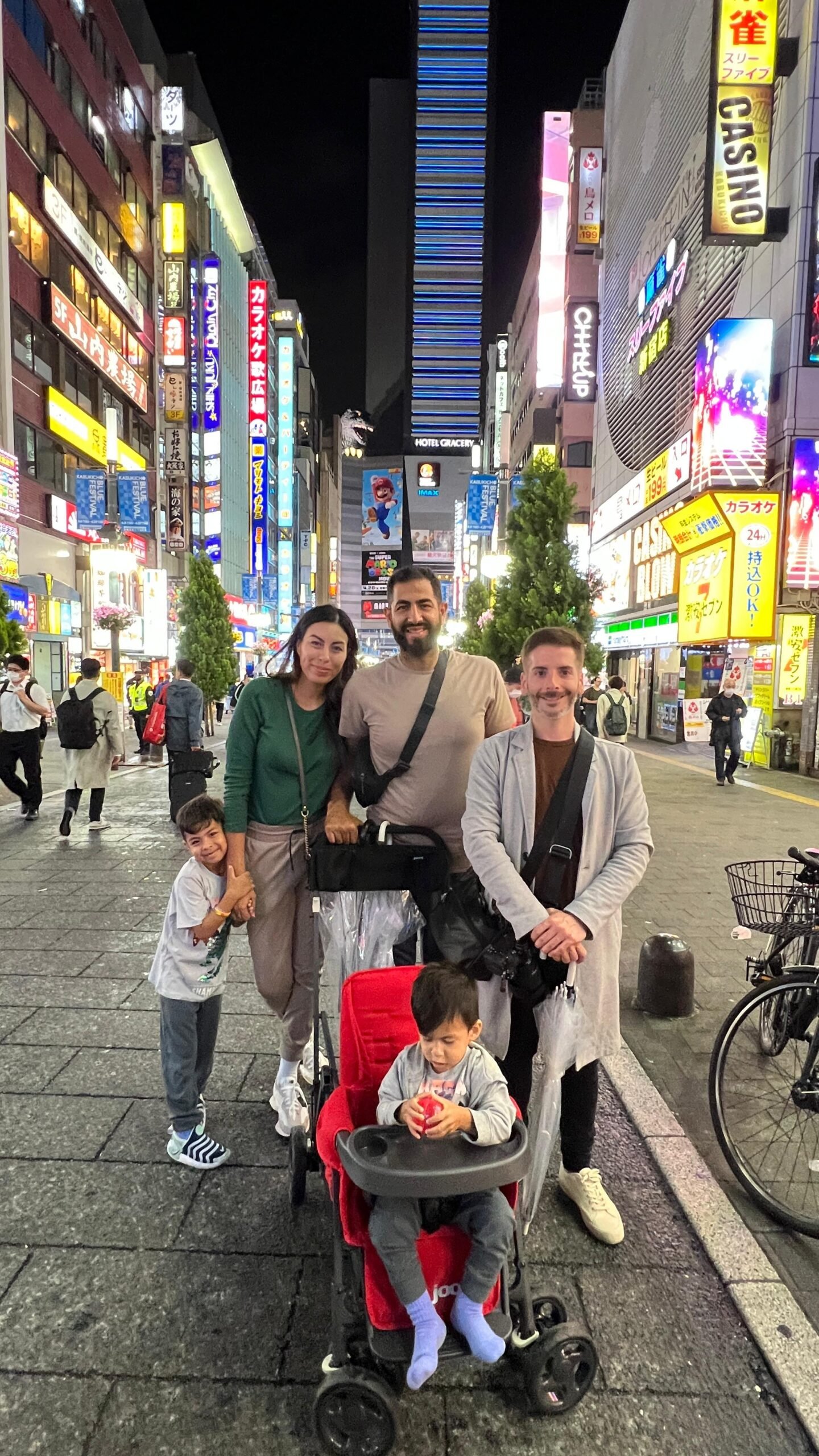 Carlos con una familia viajera en una calle iluminada de Tokio por la noche