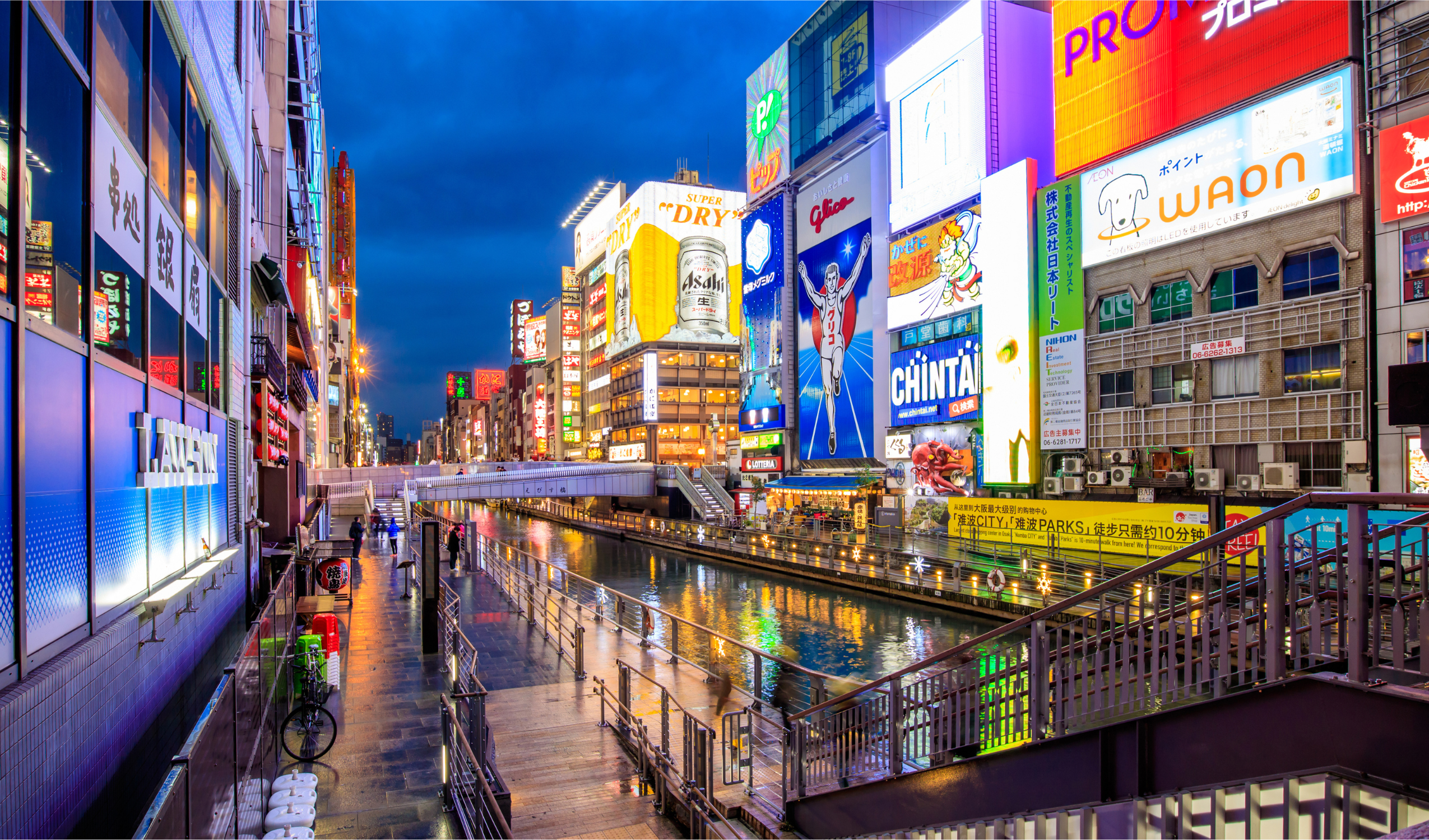 Canal de Dotonbori en Osaka de noche con carteles luminosos y ambiente urbano en Japón