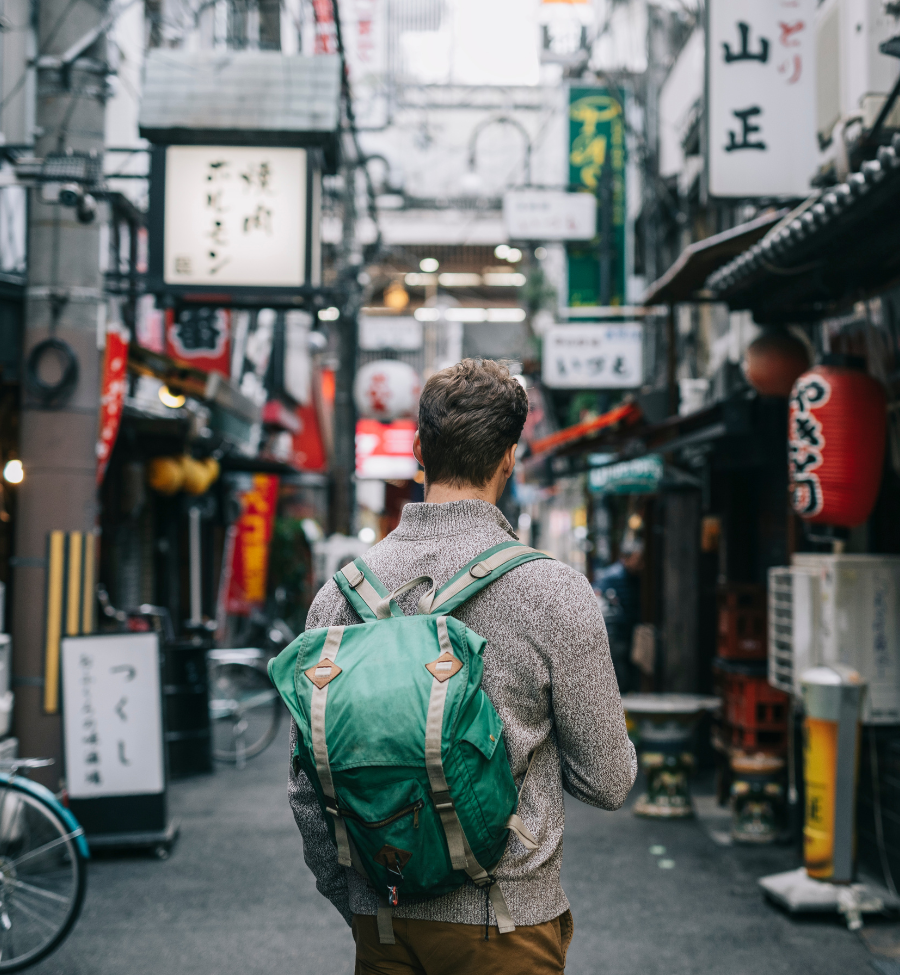 Viajero caminando por una calle tradicional de Japón con mochila